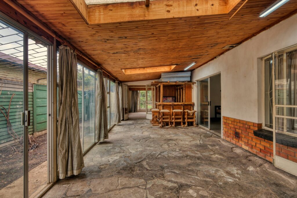 Spacious sunroom with sliding glass doors and rustic decor for a cozy home extension.